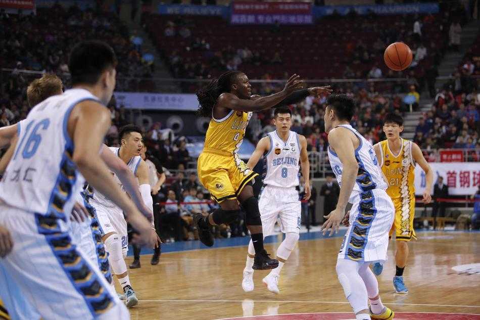 京城攻防,广厦登顶:胡金秋引领半程冠军之夜 广厦队主帅李春江在场边大声指挥,他手势果断,眼神犀利,身后是密密麻麻的球迷看台,氛围紧张热烈。