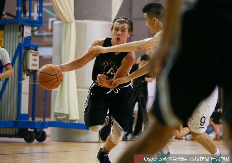 京城篮坛青春对决:北京四中激战美国联队七分之差 跳球瞬间,北京四中的高个球员奋力跃起,指尖几乎触碰到球皮,对面美国联队的球员则绷紧肌肉,空中形成一幅力量与高度对抗的剪影。