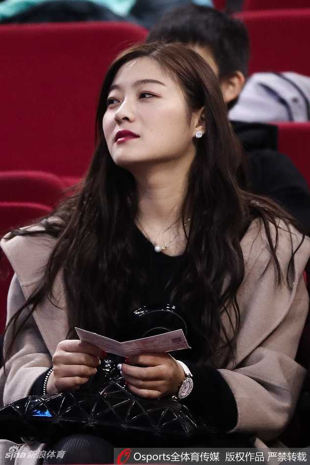 比赛结束后的看台上，一位戴着毛线帽的美女球迷正准备离场。她的脸上还残留着因比赛而产生的红晕，嘴角微扬，似乎还在回味刚才的精彩瞬间。喧嚣散去，留下的是一份满足的观赛记忆。