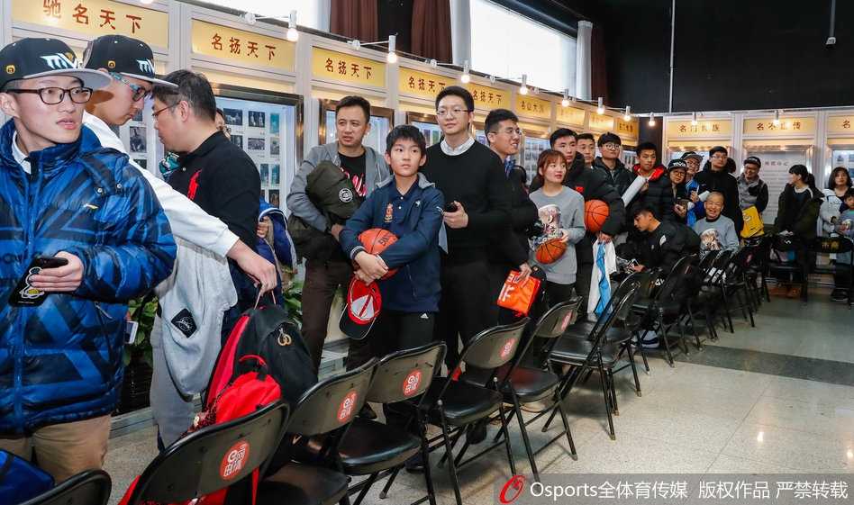 人山人海的签售大厅里，马布里坐在桌前专注地为球迷签名，背景墙上挂着他不同时期的经典照片，排队的球迷们井然有序地向前移动，手中拿着海报和纪念品，眼神中充满期待。