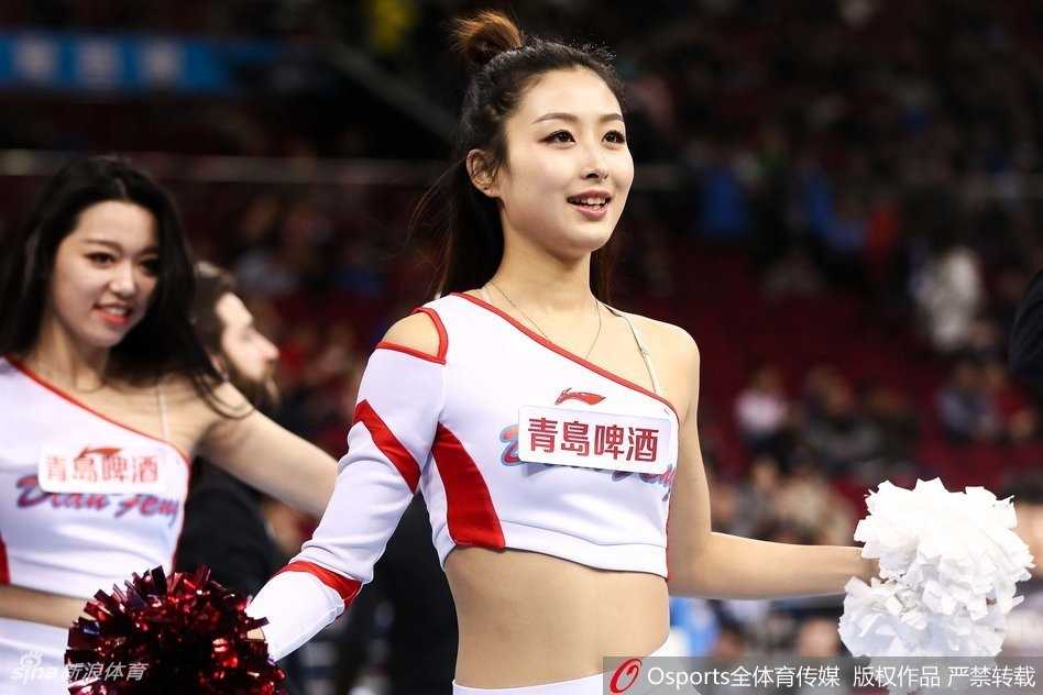 镜头拉近，这位篮球宝贝的笑容极具感染力，她头戴闪亮的银色发饰，伴随着强劲的鼓点有力地挥舞着手臂，那股自信与张扬瞬间点燃了全场的热情。