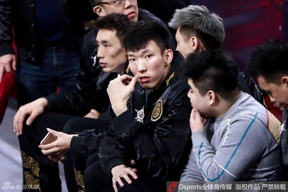 身披长款羽绒服的周琦神情专注地坐在场边，目光深邃地注视着场上年轻后辈的每一次拼抢，仿佛看到了自己曾经驰骋星锐赛的影子。