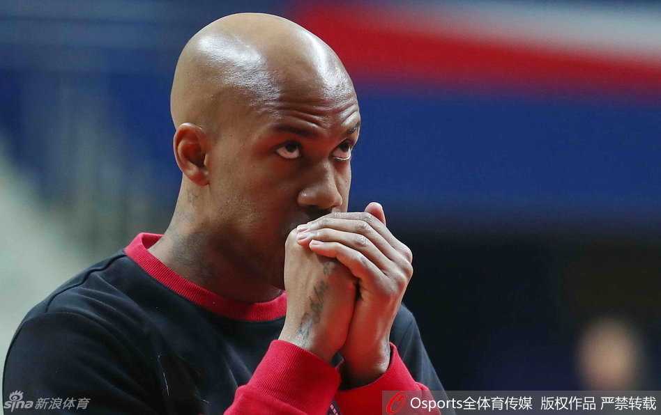 杰瑞特坐在场边接受治疗，眉头紧锁；段江鹏在一旁持球热身，眼神专注，准备随时听候调遣。