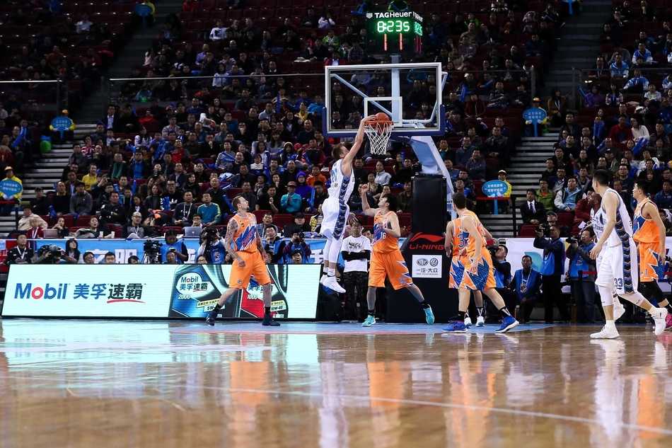 翟晓川在对抗后失去重心倒地，但依然死死将球抱在怀中，眼神中透露出不服输的拼劲，身旁是上海队员无奈的表情。