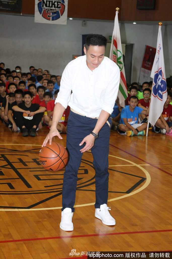 球场上何润东运球动作娴熟眼神专注，虽然脚伤未愈但风采依旧，正耐心地为学生们进行示范指导。