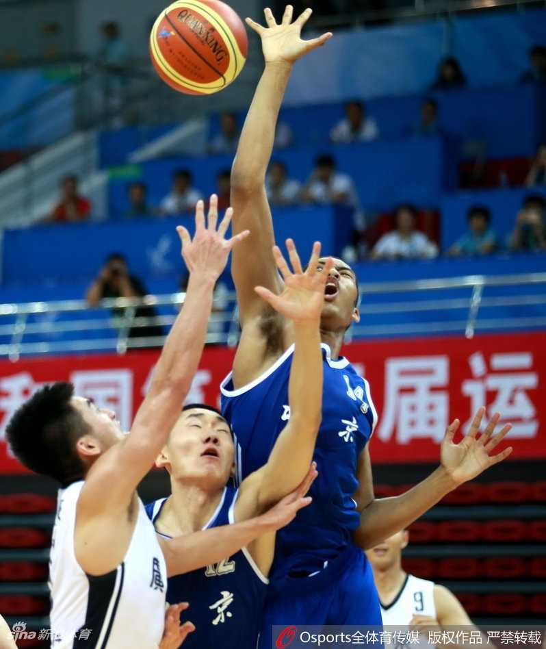 北京队常林在篮下顶着防守强起，肌肉碰撞的瞬间充满了力量感，他奋力将球放入篮筐，为球队紧咬比分。