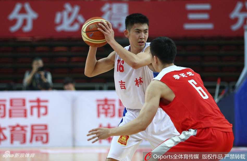 解放军队后卫在三分线外稳健地运球组织进攻，他一边观察队友的跑位，一边用手势指挥着战术，眼神中透露着沉着与冷静。