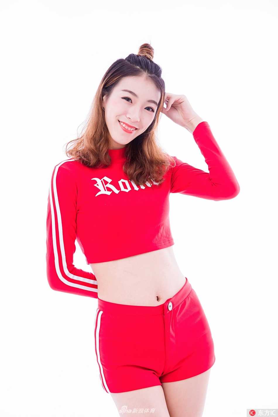 特写镜头中，一位篮球宝贝回眸一笑，紧身衣勾勒出她纤细的腰肢，高高束起的马尾辫显得活力四射，背景的柔光打在她精致的脸庞上，流露出青春独有的自信与魅力。