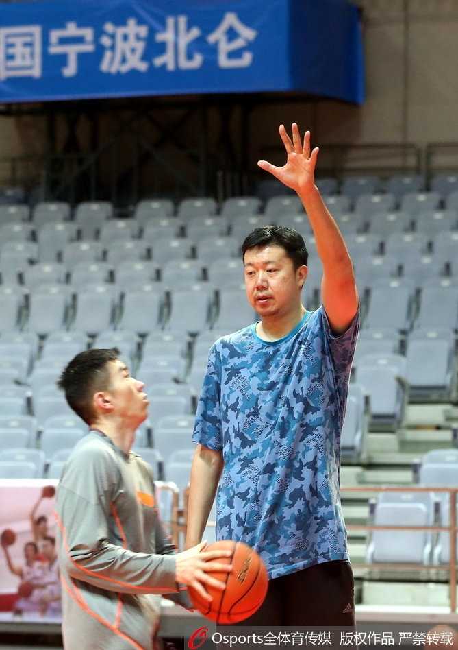 八一男篮新周期蓄力起航,王治郅身披教练战袍督训传薪火 王治郅身穿深色运动外套,双手环抱胸前,目光如炬地凝视着场内球员的折返跑训练,神情专注而严肃。