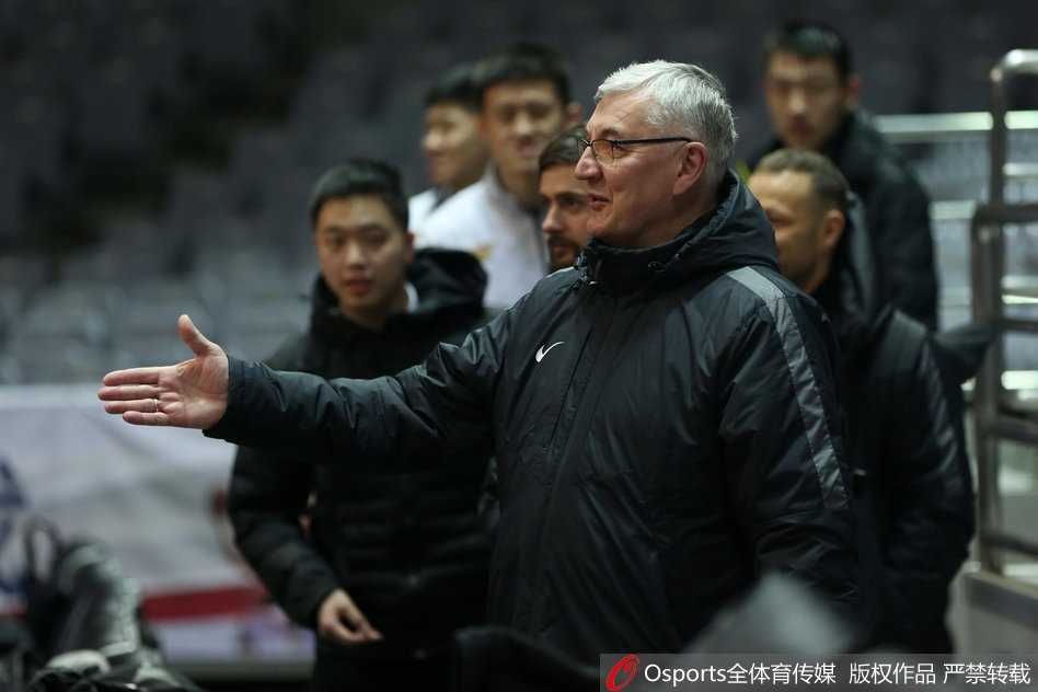 王治郅身穿黑色训练服，神情专注地给八一队年轻中锋讲解跑位路线，他用修长的手臂在空中划出战术弧线，年轻球员频频点头，眼神中透露出渴望进步的决心。
