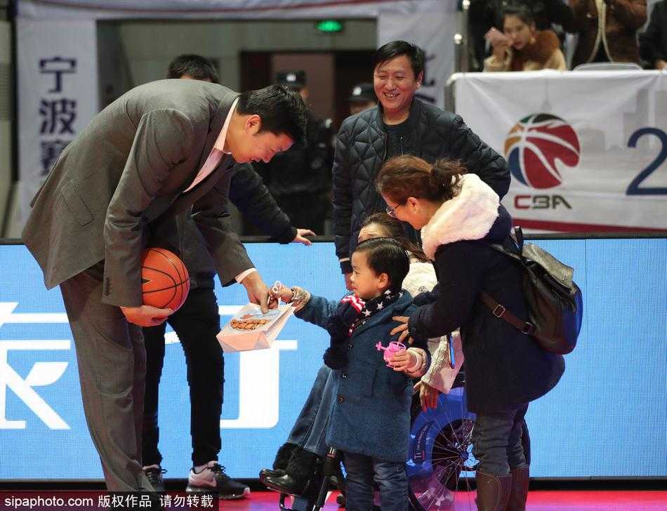 桑兰面带温柔笑意坐在看台上，丈夫黄健细心地为她调整着大衣的领口，身旁年幼的儿子黄鹏瞪着好奇的大眼睛打量着球场内的喧嚣。