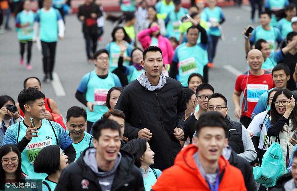 易建联在马拉松人群中露出爽朗笑容，他与周围的跑友轻松互动，冬日的寒风也吹不散现场的欢乐气息