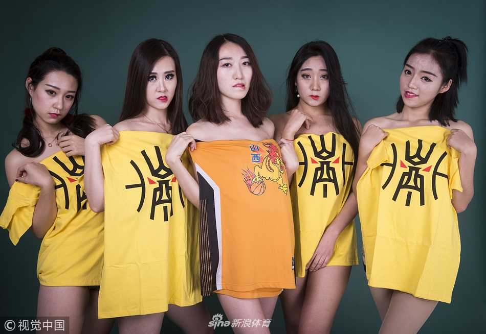 山西女篮啦啦宝贝们在赛场中央集体起舞，她们面带灿烂笑容，整齐划一的动作洋溢着青春活力，身后的巨幅队旗与她们的靓丽身影交相辉映。