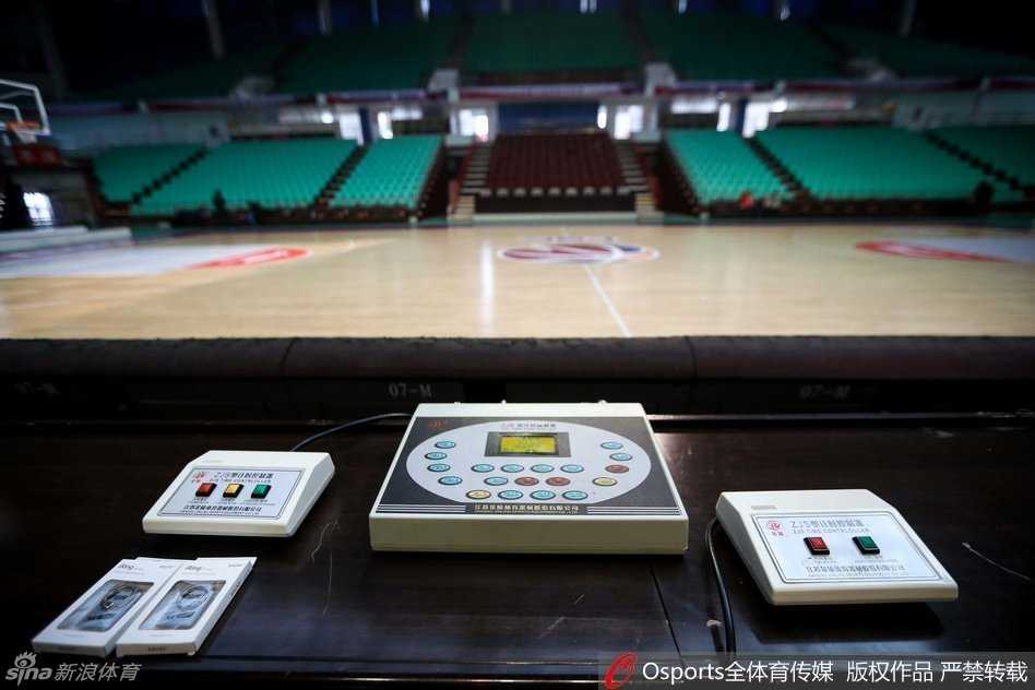 技术人员弯下腰，目光专注地审视着计时器控制主机背后的复杂线路，手中的螺丝刀轻轻调整着接口，仿佛外科医生在进行一场精密的手术，确保电子信号的每一次跳动都准确无误。