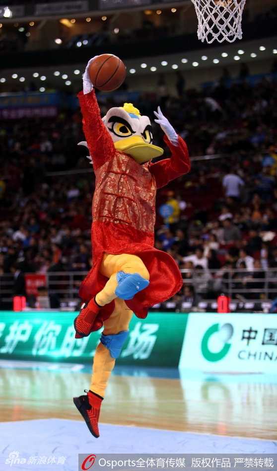 霹雳鸭身着红色唐装，正弯下腰与场边一位同样穿着红色棉袄的小朋友击掌互动，小朋友脸上洋溢着惊喜的笑容。