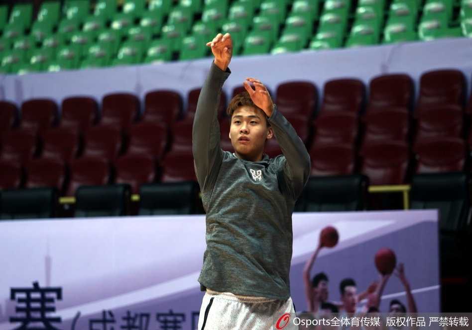 广东宏远训练馆内气氛热烈，核心易建联在折返跑后停下脚步，用毛巾擦拭如雨汗水，眼神依旧专注地盯着球场另一端的战术演练。