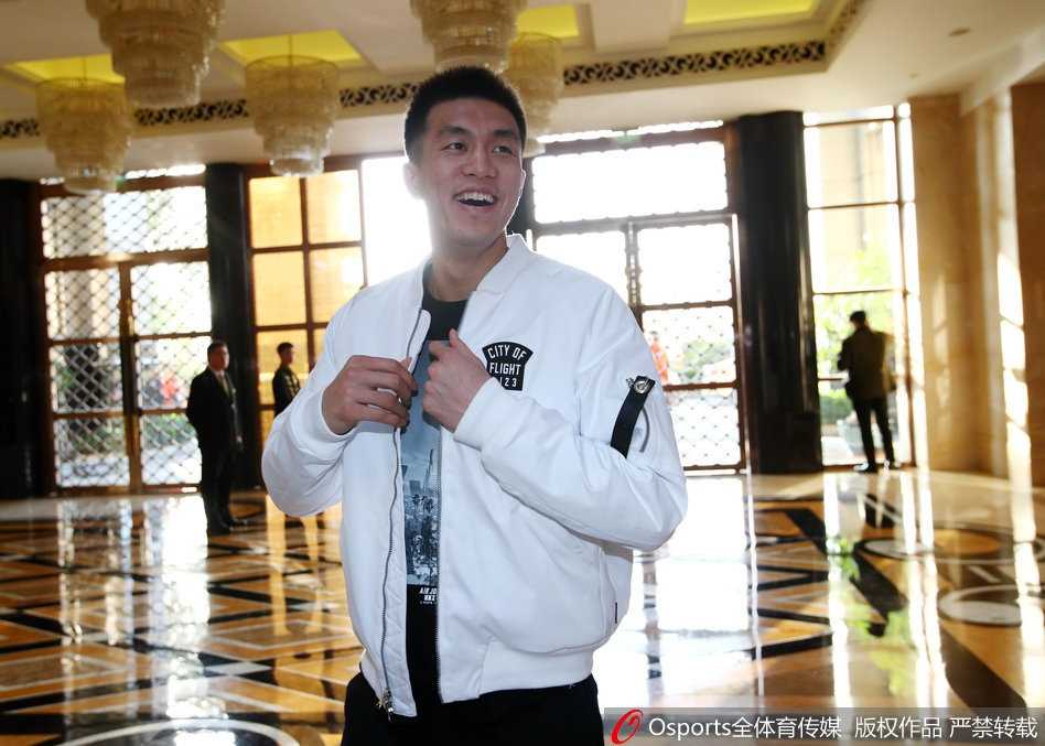 身披红色训练服的郭艾伦现身酒店大堂，面对镜头露出标志性的搞怪笑容，眼神里满是对周末轻松时光的期待