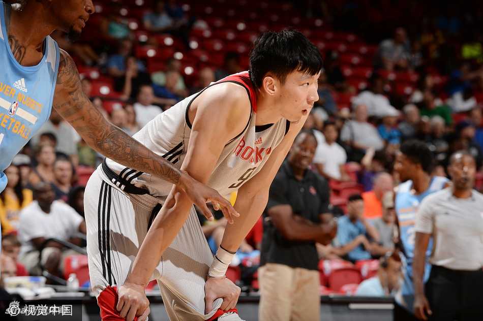 周琦身披火箭战袍在夏季联赛中持球，面对防守者神情专注，长臂舒展准备进攻。