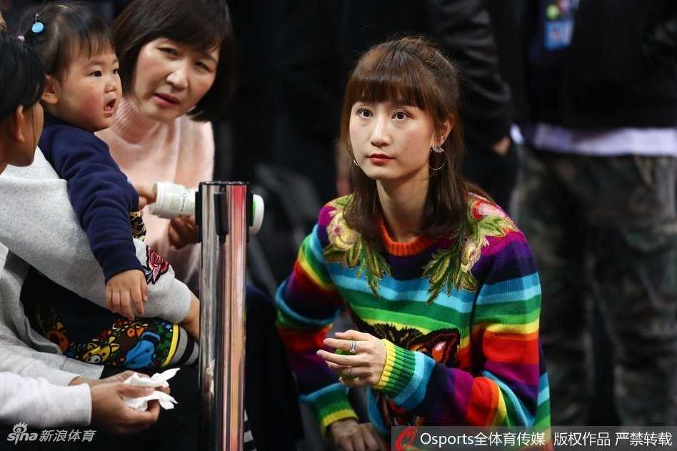 周鹏与刘美并肩而坐，两人目光一同投向赛场方向，刘美嘴角带着淡淡的笑意，周鹏则神情专注，仿佛在为场上的年轻球员们暗自加油鼓劲