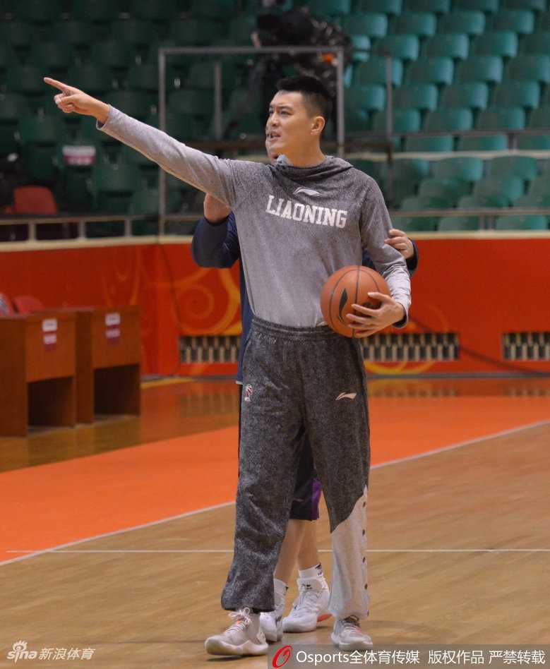 杨鸣在训练间隙回头望向场边，身后是未完成的训练和提前闯入的山东场馆工作人员，场面显得混乱而尴尬。