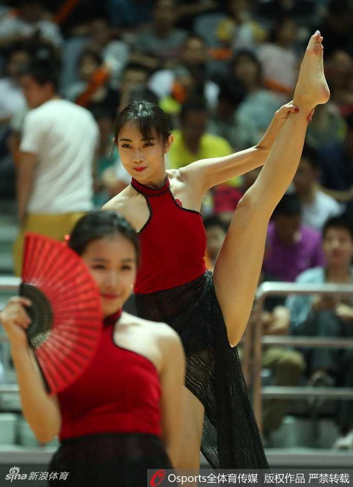 浙江蕞红啦啦队全体成员身着红白队服，手持花球在球场上排出整齐队形，笑容灿烂感染力十足