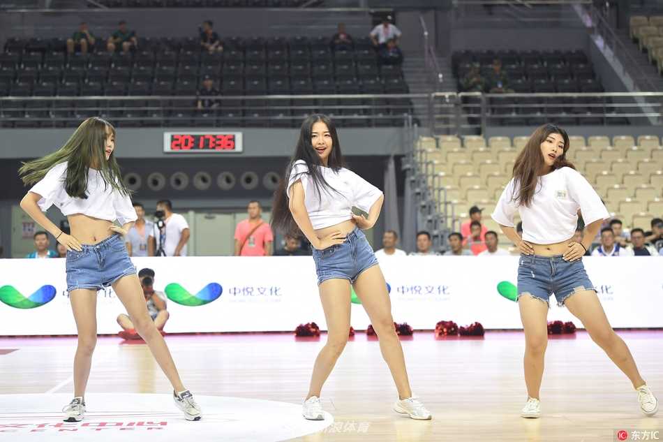 镜头拉近，一位扎着马尾的啦啦队员回眸一笑，青春的气息扑面而来，背景里是正在擦汗的辽宁队球员，一动一静构成生动的赛场画卷。