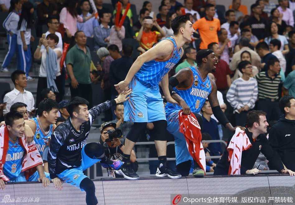 广东队领袖易建联在比赛中高高跃起，完成一记势大力沉的单手劈扣，展现出八冠王不屈的斗志，但篮下的新疆队员严密的防守让这次得分显得尤为艰难。