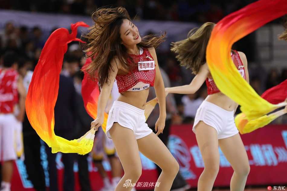 即使是静态的图片，仿佛也能感受到现场震耳的音乐。两位啦啦宝贝背对背摆出酷炫的造型，她们的力量与柔美完美结合，引得看台上的观众纷纷举起手机记录这一刻。