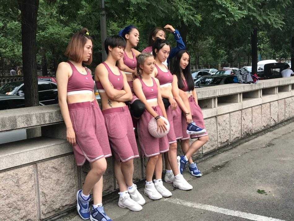 一位队员在人群中回头，眼神清澈而坚定，她身上Pigalle联名款独特的色彩拼接设计格外抢眼，背景是模糊的观众看台，仿佛整个世界都在为她定格。