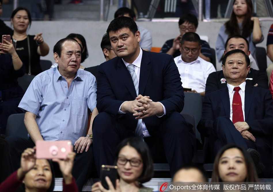 巨人俯瞰赛场，姚明与李金生在广东德比战看台上神情专注，目光如炬地审视着场上的每一次攻防转换。