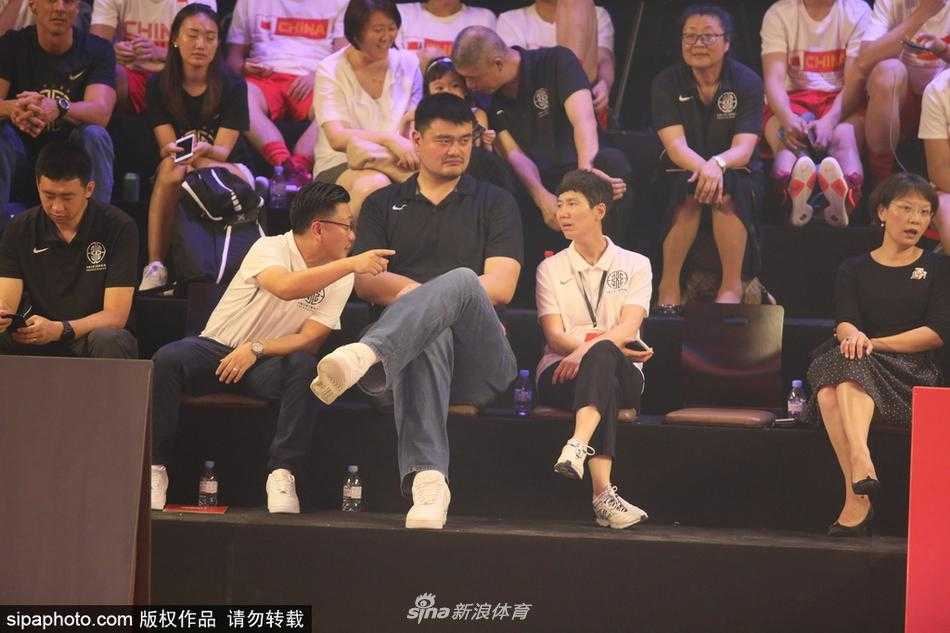 姚明助力三人篮球从街头走向奥运殿堂 姚明手持篮球仔细观察,身旁的奖杯熠熠生辉,仿佛在传递着对草根冠军的致敬