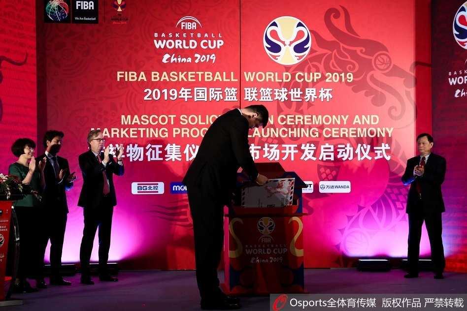 姚明发出诚挚邀请函,全球共绘篮球世界杯吉祥物中国梦 仪式现场高朋满座,姚明与几位中外嘉宾并肩站立,大家神情愉悦地相互交流,背景是巨大的活动主题板,空气中弥漫着合作与共赢的友好氛围。