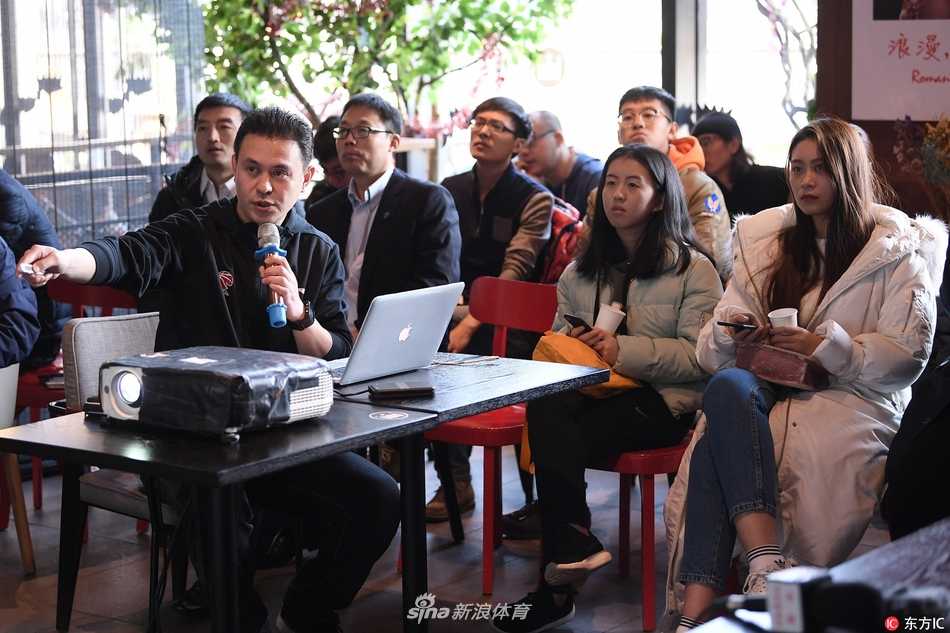 姚明携裁判直面争议 详解CBA联赛执法风云 媒体之家活动全景,长桌旁围坐着数十位媒体记者和工作人员,背景屏幕上显示着CBA联赛的标志,气氛轻松而专注。