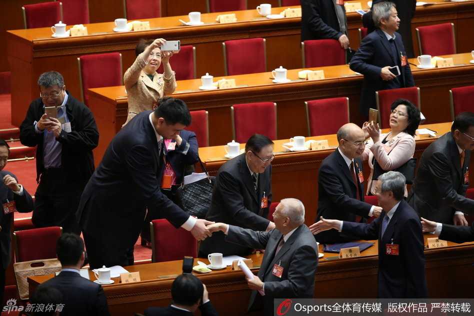 姚明政协发声:体育强国的根基在于群众的热爱与市场的沃土 姚明结束发言后回到座位,他面带微笑与旁边的委员进行交流,神态放松,远处会场的灯光璀璨,背景中能看到其他委员专注的神情,这一刻充满了履职后的释然与继续前行的力量。