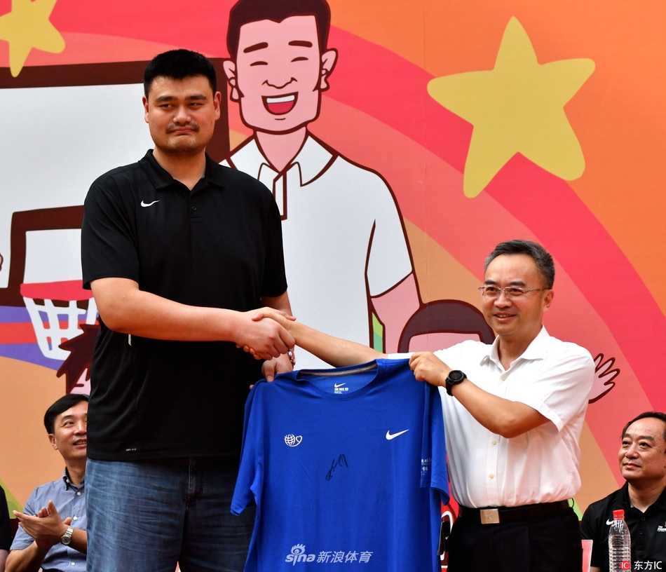 烈日下，身穿黑色T恤的姚明耐心指导几名小球员进行运球训练，他庞大的身影与孩子们娇小的身形形成对比，篮球的梦想就此生根发芽。