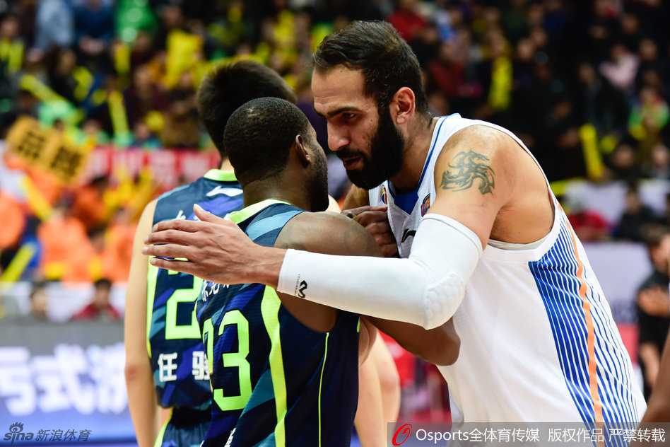 宿敌之战:易建联与哈达迪的内线巅峰对决 易建联果断跳投,哈达迪伸手封盖,内线巨人的空中对决。