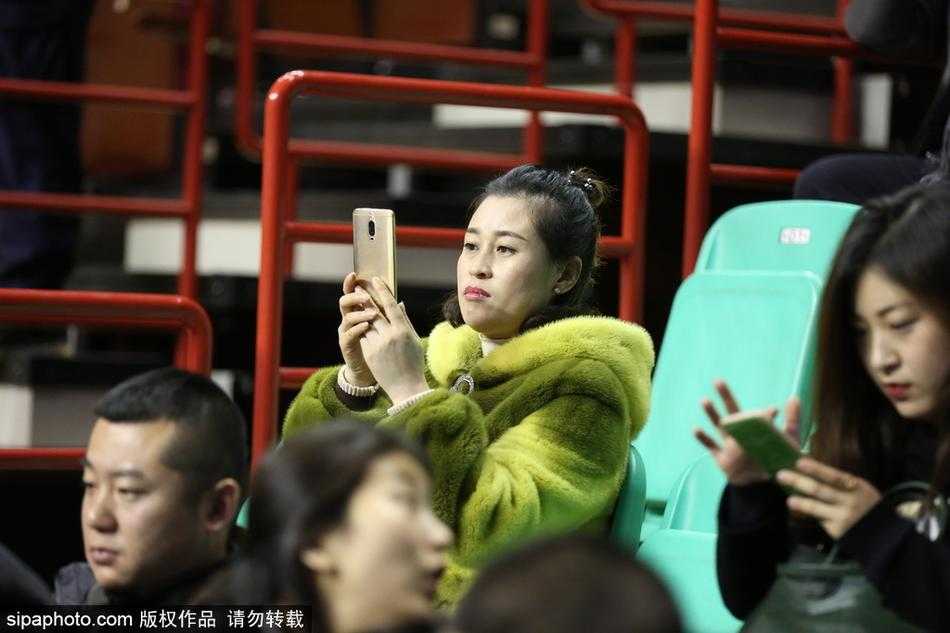 寒冬貂绒助威,辽宁本溪主场球迷彰显豪迈真情 一位年轻球迷将貂绒大衣搭在肩上,内搭辽宁队的红色球衣,他面带笑容指着球场方向,仿佛在向同伴夸赞今晚主队的出色表现。