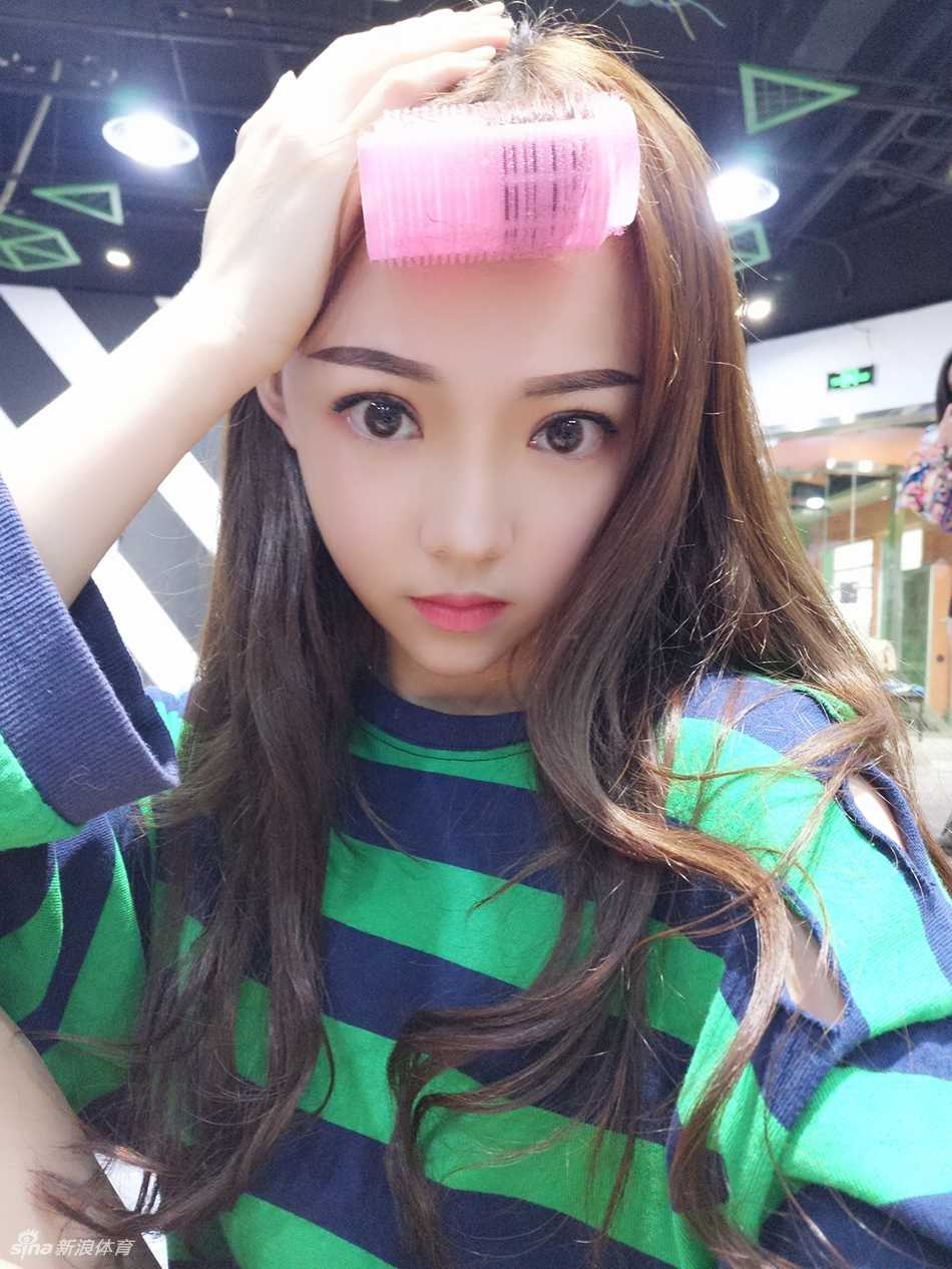 小惠俏皮比心，眼中闪烁着青春光芒，脸颊上带着可爱的酒窝