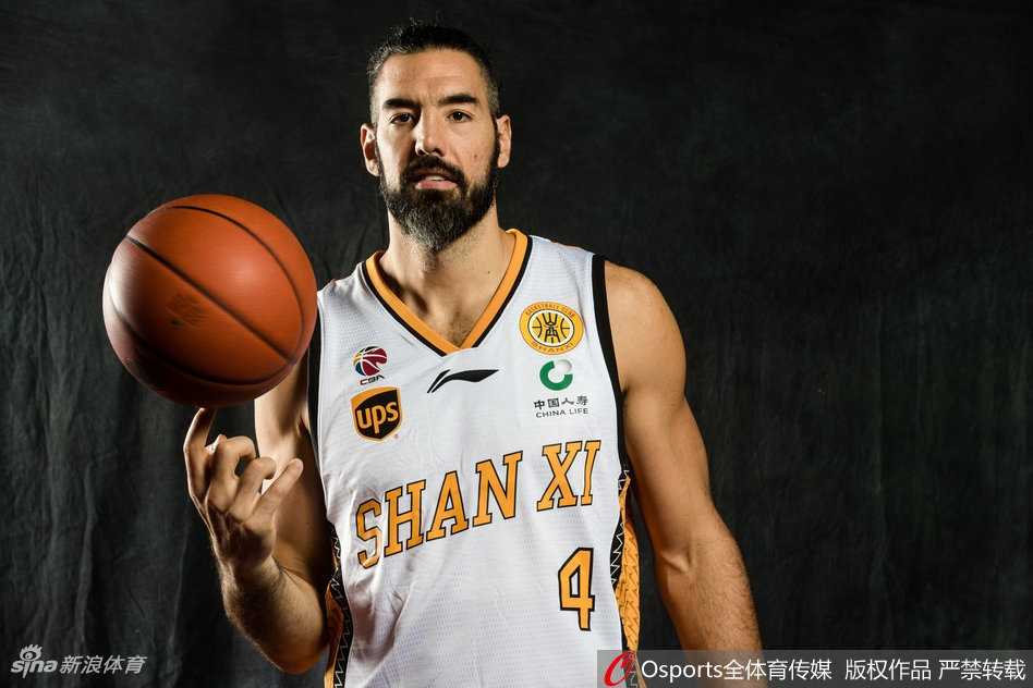 山西男篮众将写真场外:搞怪不停,其乐融融迎新生机 一名山西男篮年轻队员正在进行个人动作写真拍摄,他高高跃起试图完成单手劈扣,身体在空中充分伸展,充满了力量感与爆炸性的视觉冲击。