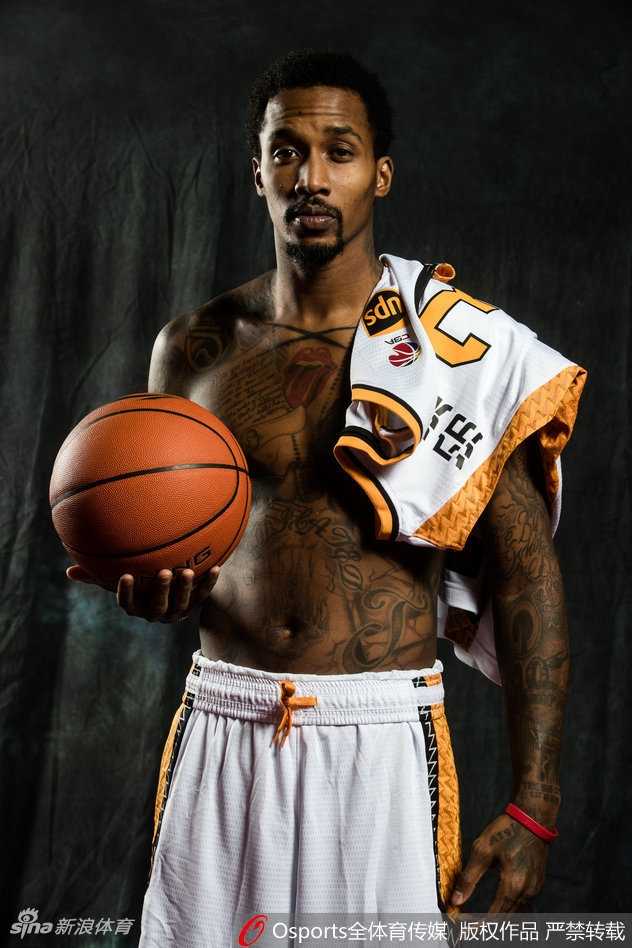 山西男篮众将写真场外:搞怪不停,其乐融融迎新生机 山西男篮教练组与队员们一起拍摄大合影,大家紧密地靠在一起,对着镜头露出灿烂的笑容,教练也比出大拇指,背景是球队新赛季的官方背景板,气氛融洽。