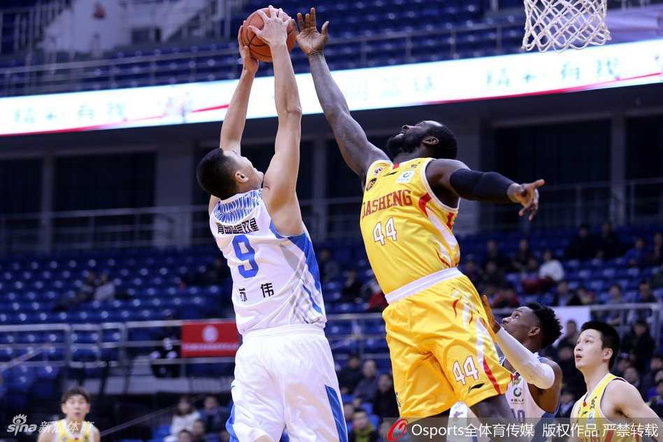 青岛队球员高尚在对手严密防守下依然眼神坚毅，如利刃般撕开防线完成上篮