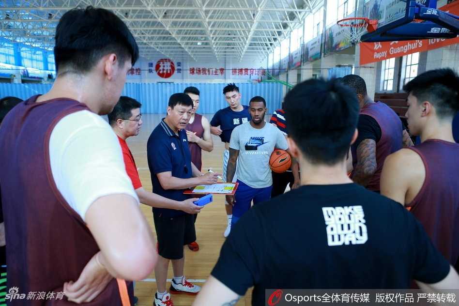 飞虎训练营内，主帅李秋平神情专注，双手比划着复杂的战术跑位，队员们围成一圈，眼神中透露出对胜利的渴望。