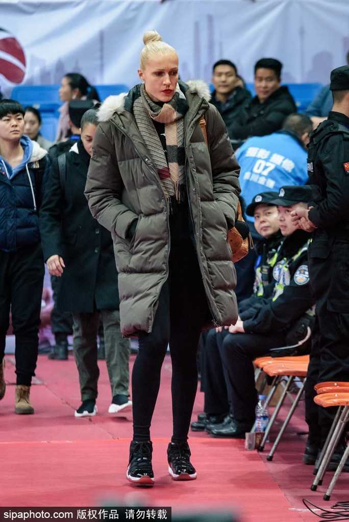 灯光聚焦的赛场中央，四川女篮外援专注地凝视着场内，她的眼神中透露出对职业篮球的深刻理解与对激烈对抗的浓厚兴趣。