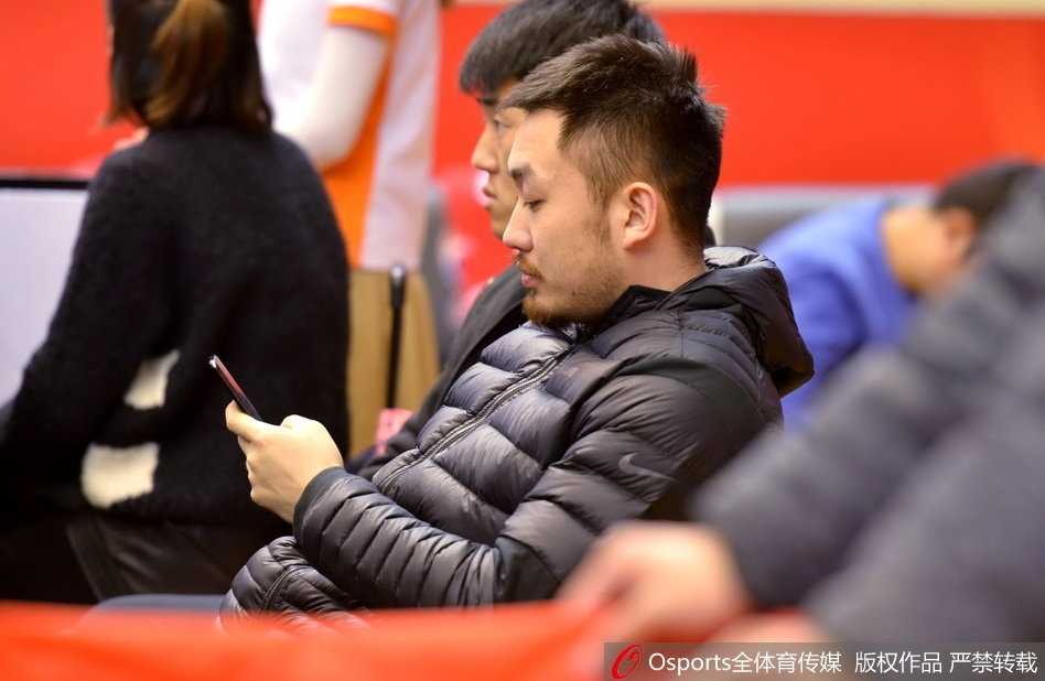 睢冉双手抱在胸前，静静地坐在替补席上观看比赛，受伤的左脚穿着特制的保护靴架在地面上，他的目光深邃而坚定，仿佛在用另一种方式守护着球队。