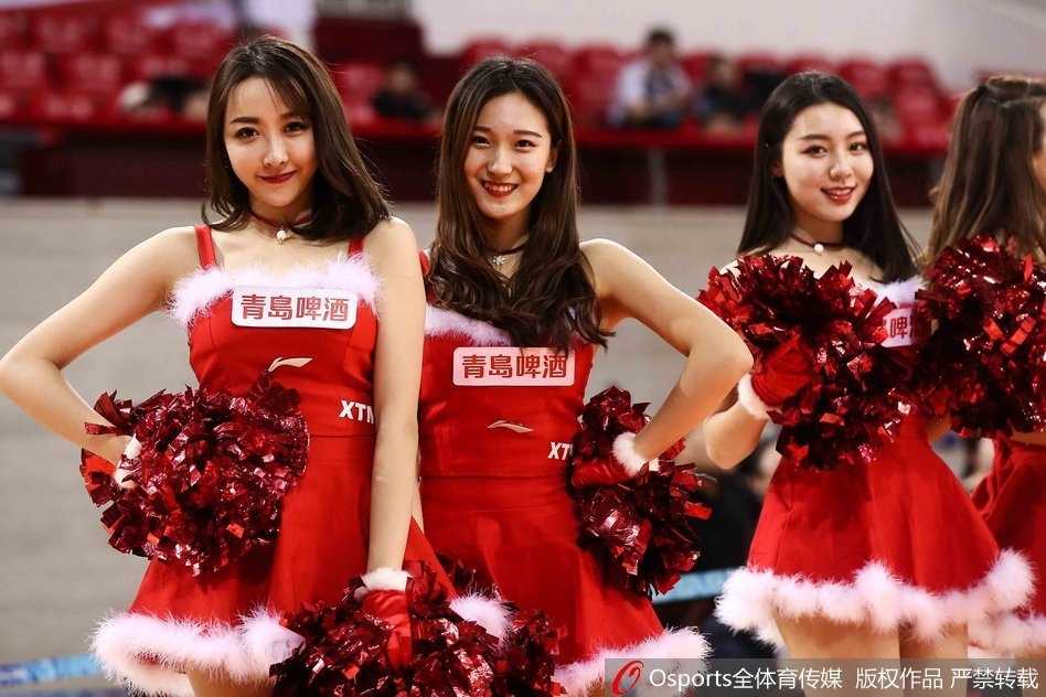 镜头拉近，宝贝双手轻摆，身姿曼妙，裙摆上的金色亮片在灯光下闪闪发光，如同圣诞树上最耀眼的装饰。她专注的神情不仅是在完成一次表演，更是在与看台上的球迷进行一场无声的互动。