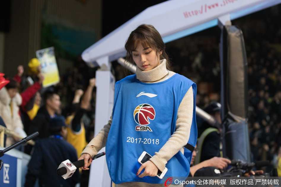 聚光灯下，广厦主场美女主持手持赛事资料，眉眼间流露出对比赛的专注与柔情，仿佛在为场上每一次攻防心跳加速。