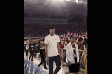 动图记录下阿联被热情歌迷包围的瞬间，人群如潮水般涌来，他那标志性的微笑在人群中若隐若现，展现了巨星独特的亲和力。