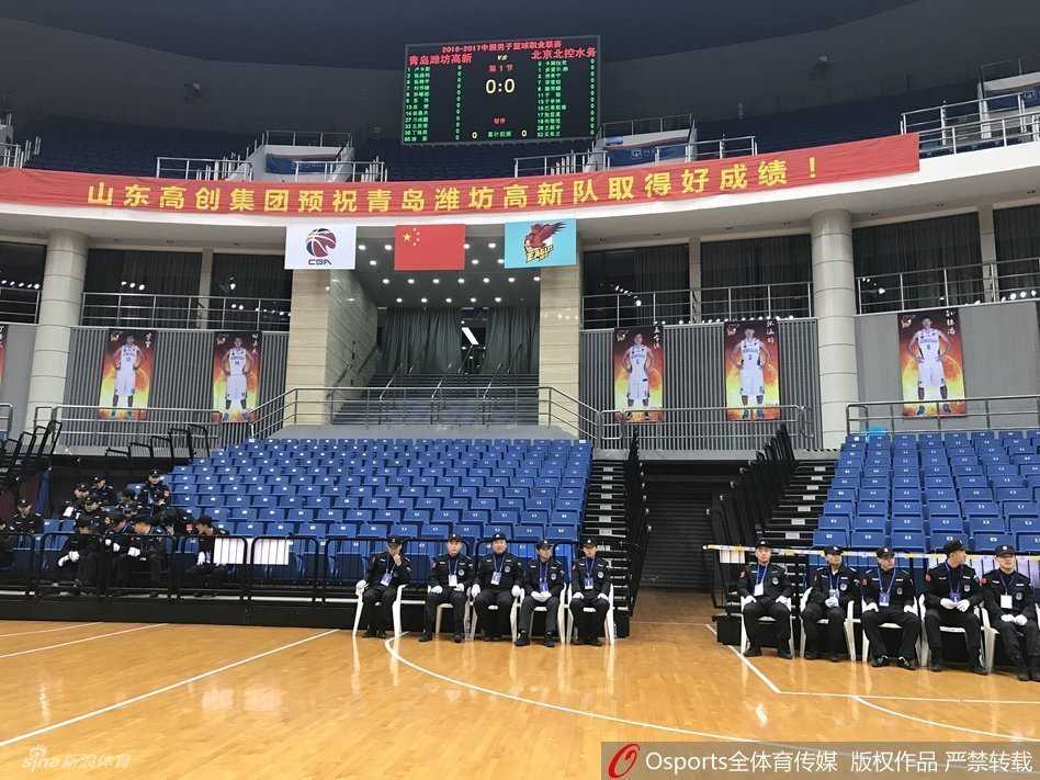 当篮球架遇见演唱会舞台:一场因“跨界”而取消的CBA比赛 比赛当晚,青岛国信体育馆外围广场上,大批得知比赛取消的球迷神情茫然地聚集在一起,有的低头看着手机确认消息,有的正在与同伴议论,背景是体育馆亮着灯光的外立面。