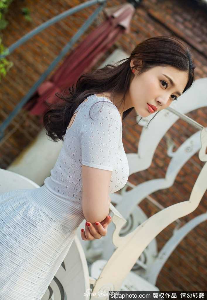 徐冬冬手持白玉兰在胸前，白裙与白玉兰相映成趣，她对着镜头露出浅淡而真挚的微笑，画面定格在最美好的瞬间，诠释了何为“人比花娇”。