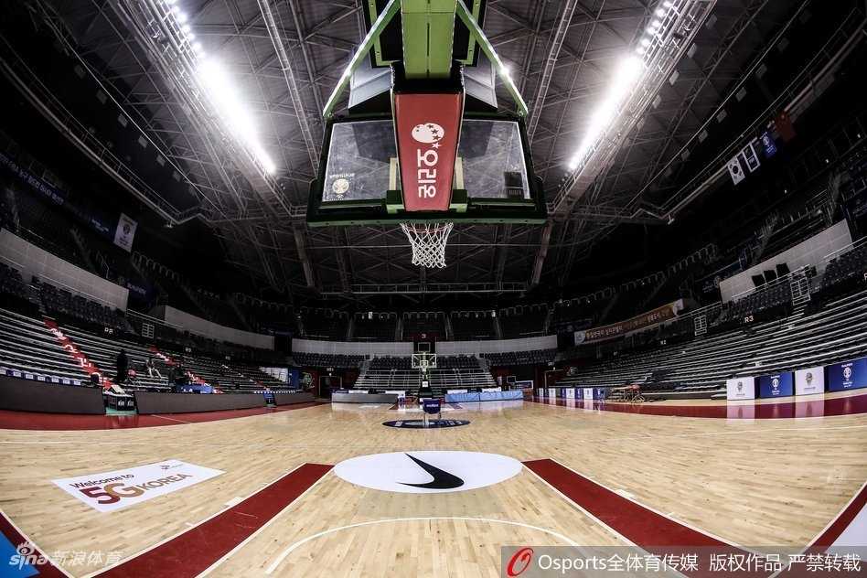 探访韩国高阳战场,男篮红队客场力克宿敌书写新篇章 韩国队的教练组在场边进行战术布置,主帅许载手拿战术板表情严肃,身后是韩国国旗和世预赛的标志